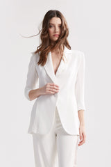 Custom made blazer featuring 3/4 length sleeves, side vents, notched lapel, front seams, and an oversized statement button.